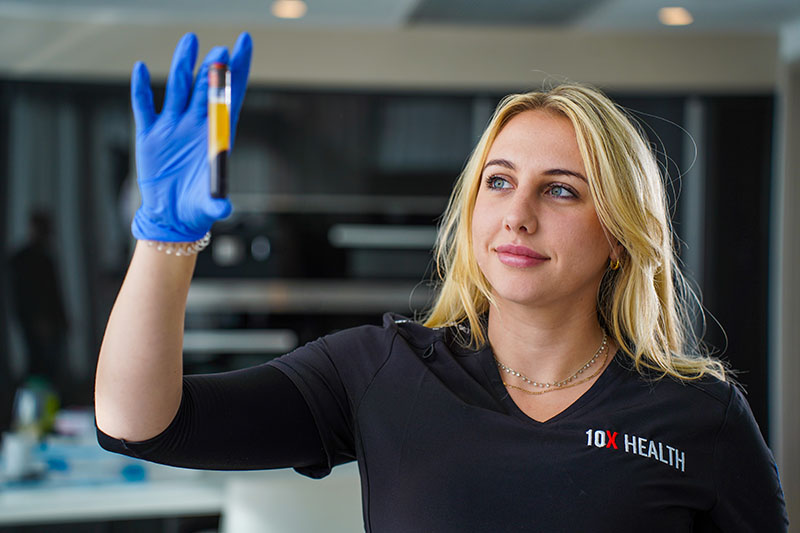 10X Health System Expert Holding A Vial of Blood for Blood Testing