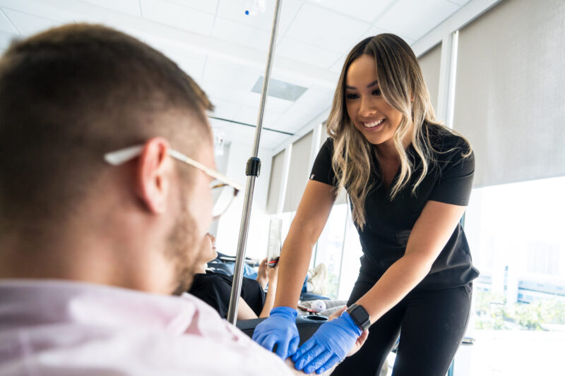 a 10X Health team member prepping a visitor for an IV a 10X Health team member prepping a visitor for an IV